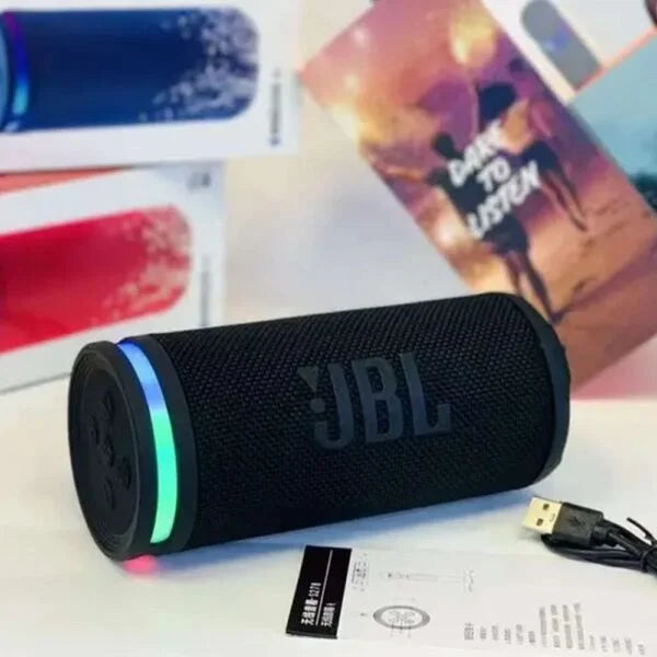 Black JBL speaker with colorful lights on a surface with colorful items in the background