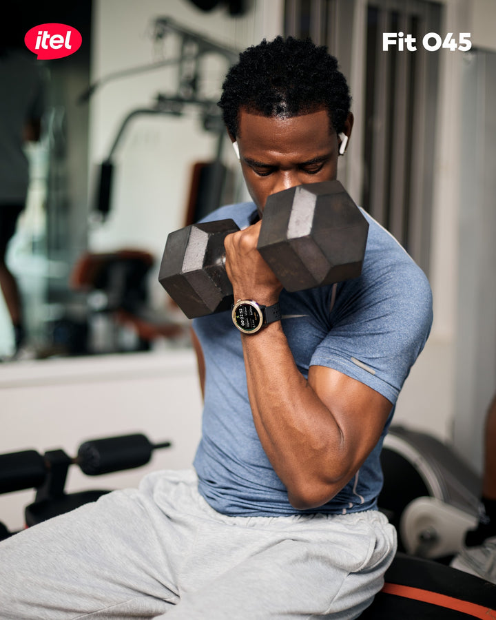 Man exercising with dumbbells in a gym setting, wearing an iitel Fit O45 device.